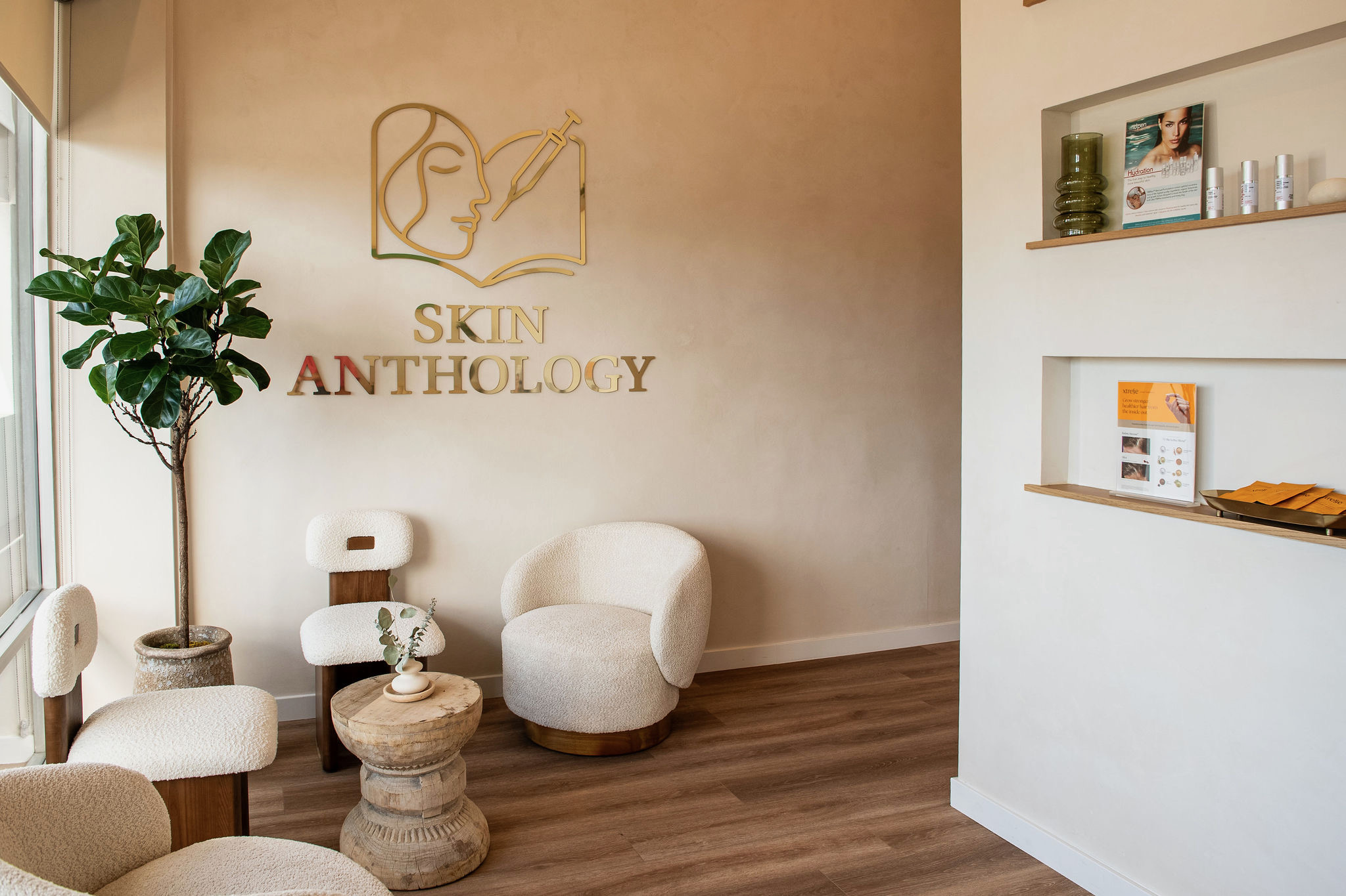 The Skin Anthology entrance lounge in Los Angeles, with the gold Skin Anthology logo on the wall